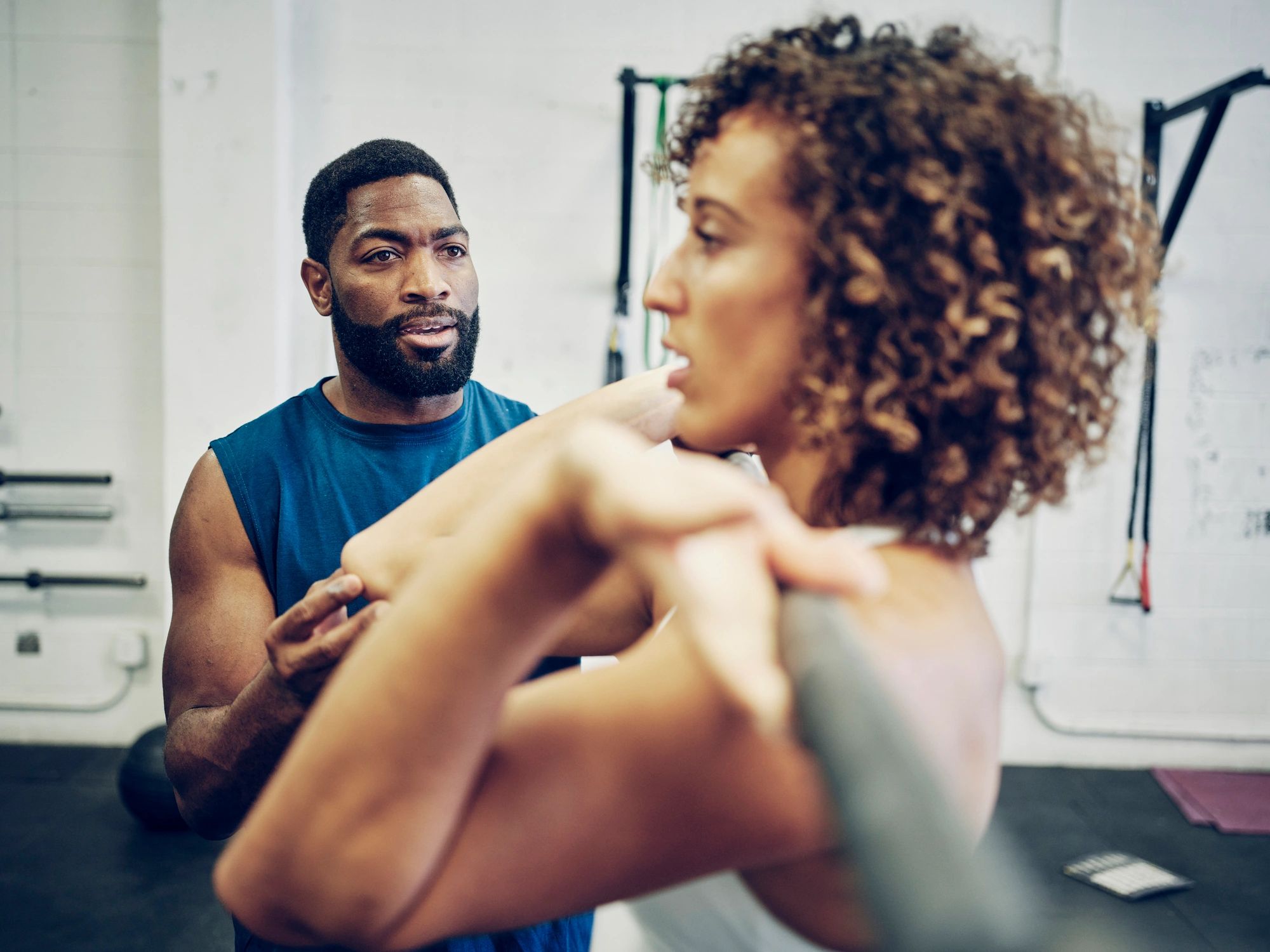 Trainer working with a client in a gym