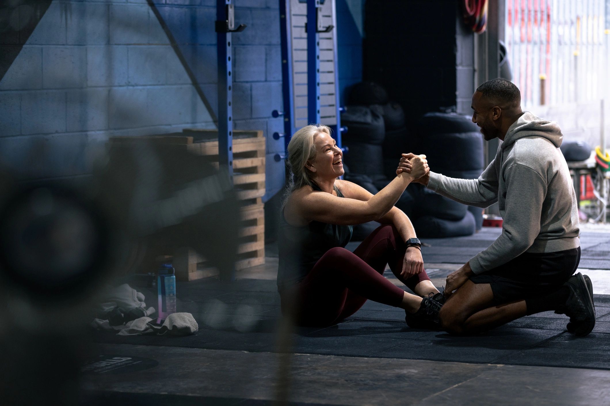 Client and trainer sharing encouragement in a gym